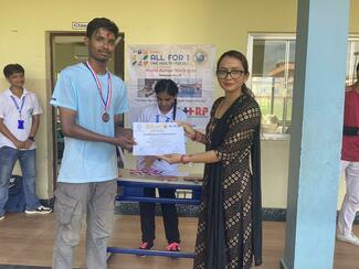 Winner of the table tennis match being awarded the certificate by the teacher