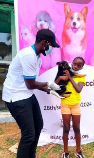 A happy pet owner getting their pup vaccinated 