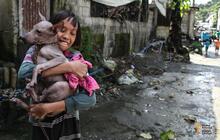 A happy girl hugging her dog closely after it got vaccinated against rabies, Philippines.