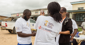 Woman and men drawing vaccine during mass vaccination campaign.